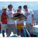 Men with dolphin caught aboard charter boat.